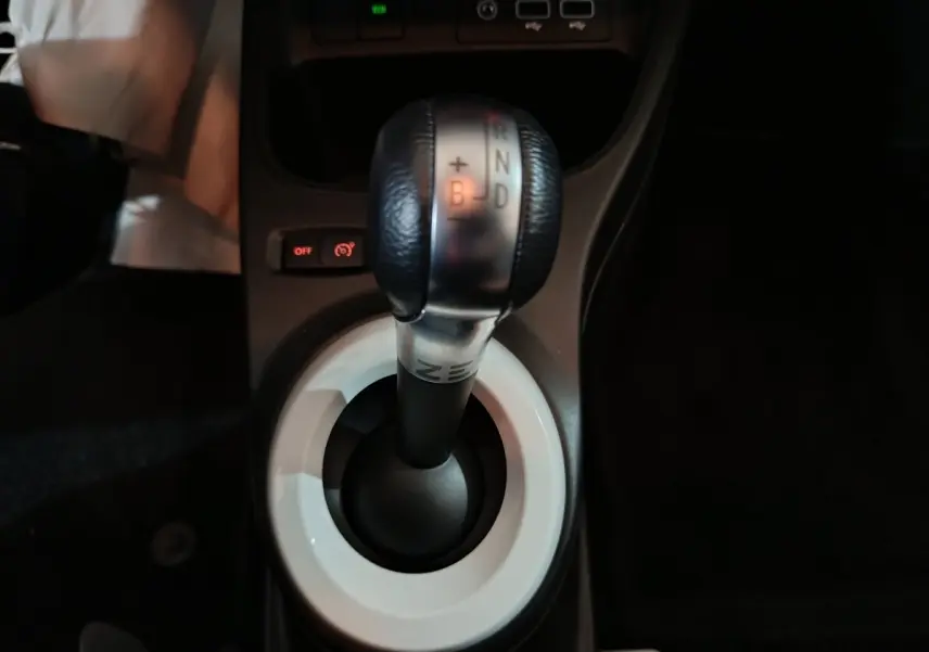 Gros plan sur le levier de vitesses automatique noir et argenté de la Renault Twingo Zen blanche, vue intérieure centrale.