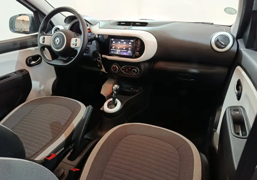 Vue intérieure côté conducteur de la Renault Twingo Zen blanche 2021 avec tableau de bord et écran tactile central.