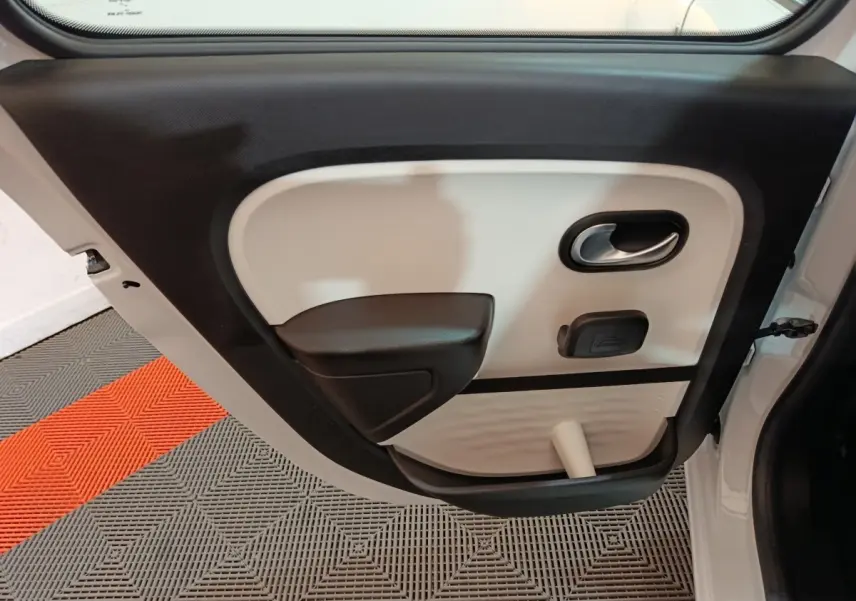 Vue intérieure de la porte arrière droite blanche d'une Renault Twingo Zen 2021 avec poignée et accoudoir noirs.