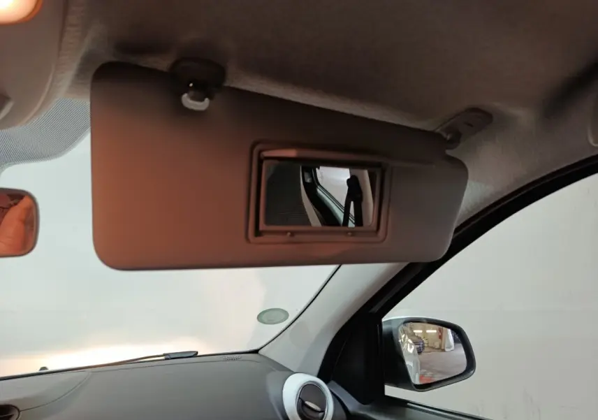 Intérieur Renault Twingo Zen 2021, vue côté passager sur pare-soleil avec miroir et rétroviseur extérieur noir.