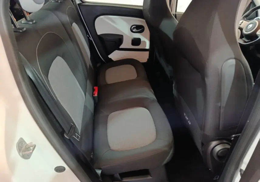 Vue intérieure sur la banquette arrière grise et noire de la Renault Twingo Zen blanche, côté gauche avec porte ouverte.
