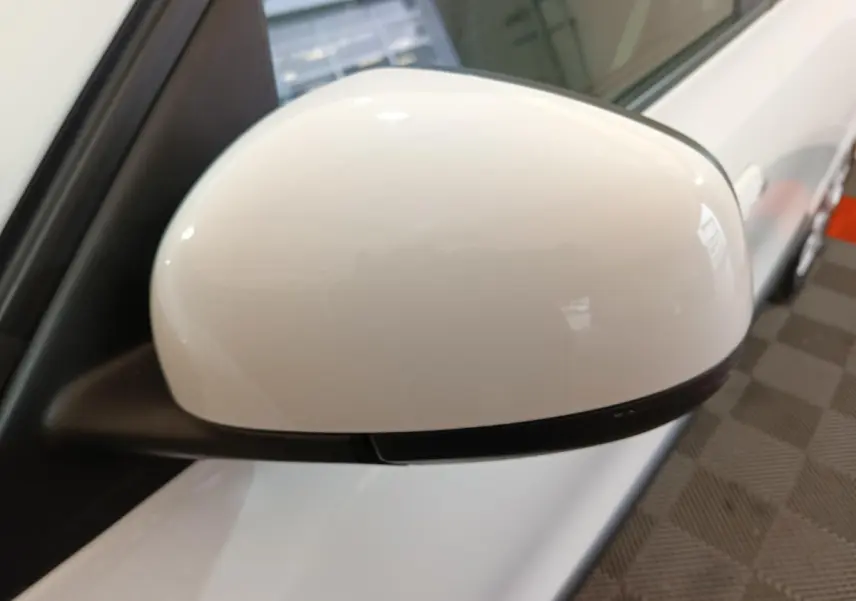 Rétroviseur côté gauche blanc de la Renault Twingo Zen électrique 2021, vue rapprochée sur porte et poignée.