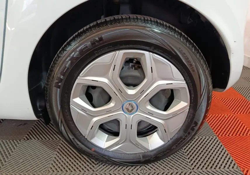 Gros plan sur la roue avant droite blanche d'une Renault Twingo Zen électrique, avec jante argentée et pneu Nexen.