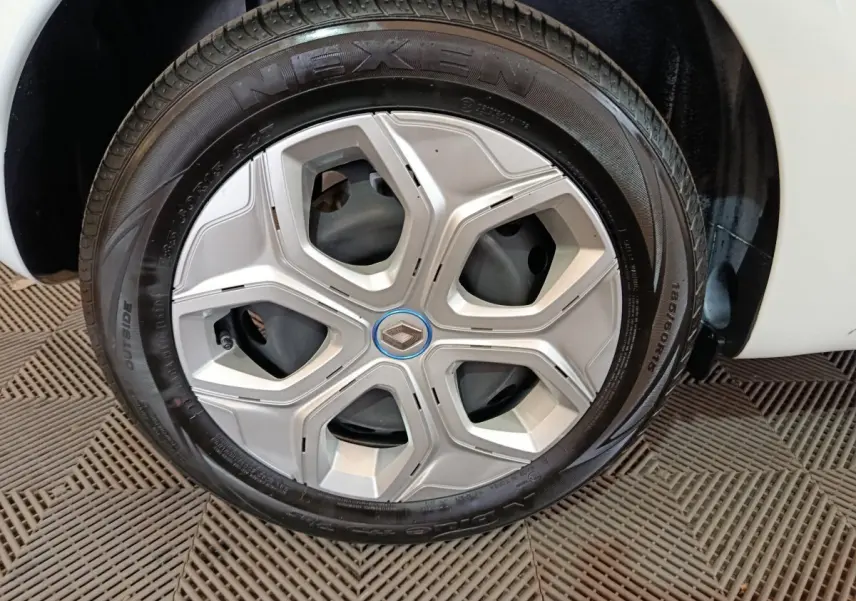 Gros plan sur la roue arrière droite d'une Renault Twingo Zen blanche de 2021, avec partie de la carrosserie visible.