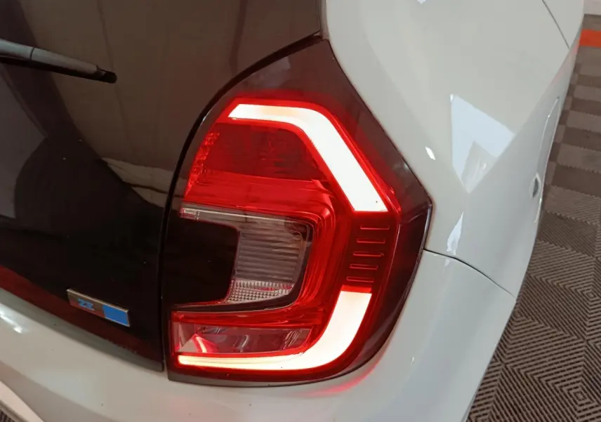Feu arrière droit allumé sur Renault Twingo Zen électrique blanche, vue rapprochée du coin arrière droit.
