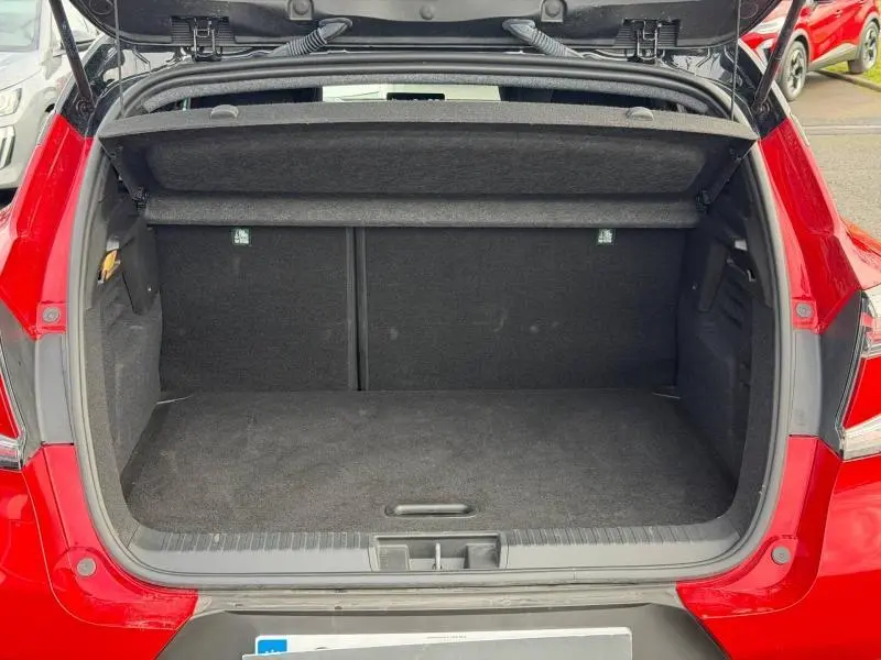Coffre ouvert vu de l'arrière d'un Renault Captur Rouge Flamme 2025, montrant l'espace de chargement vide.