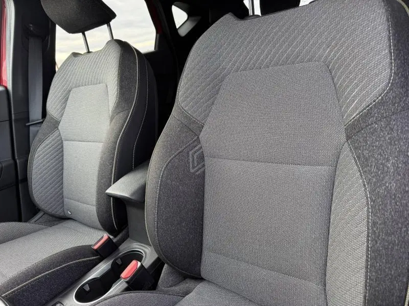 Gros plan sur les sièges avant gris du Renault Captur 2025 Rouge Flamme, mettant en valeur leur texture et finition.