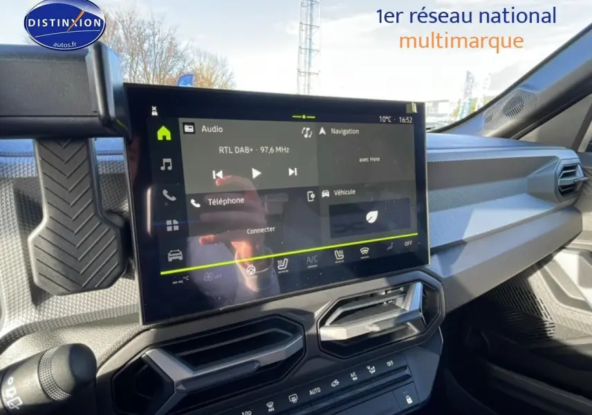 Vue intérieure du tableau de bord du Dacia Duster 2026, écran tactile multifonction et aérateurs hexagonaux noirs.