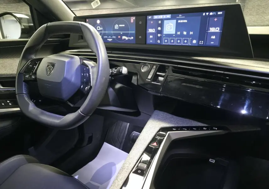 Intérieur avant droit du Peugeot 3008 bleu 2025, volant compact, double écran HD et console centrale tissu Rimini.