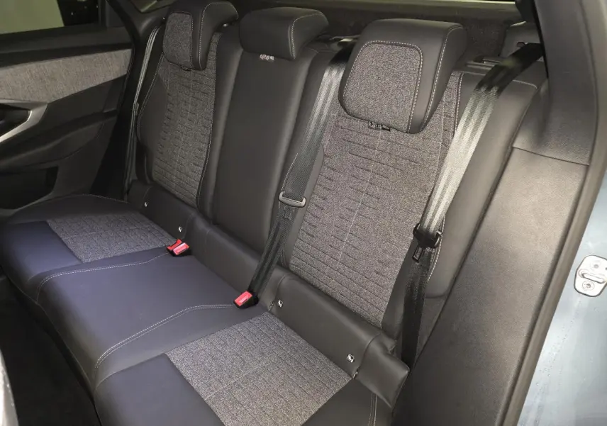 Vue côté droit des sièges arrière bi-matière gris tissu et noir cuir du Peugeot 3008 Hybrid 2025 bleu.