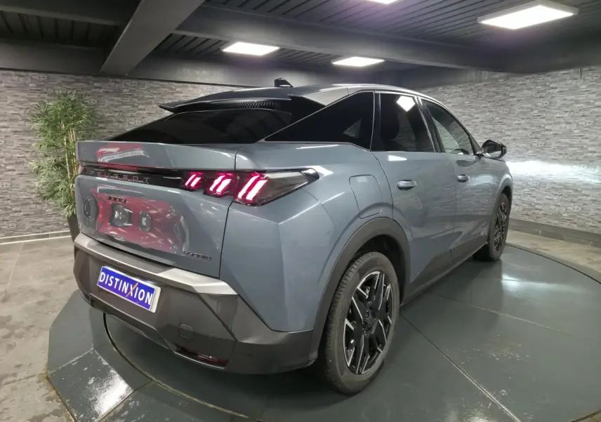 Vue 3/4 arrière droite du Peugeot 3008 hybride bleu avec feux arrière LED à trois griffes et jantes alliage noires.