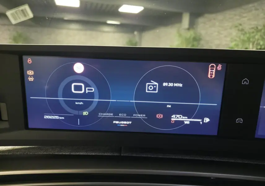 Affichage numérique du tableau de bord du Peugeot 3008 Hybrid 2025, montrant vitesse, radio et autonomie.