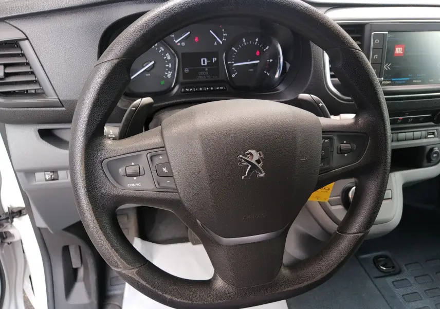 Vue rapprochée du volant noir du Peugeot Expert Fourgon 2020 avec tableau de bord et écran multimédia visibles.