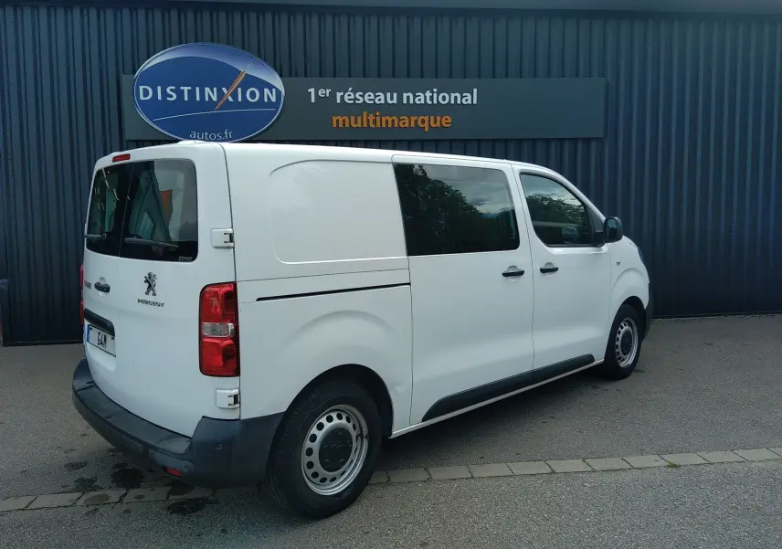 Vue 3/4 arrière côté droit d'un Peugeot Expert Fourgon blanc uni avec vitres teintées arrière et jantes acier.