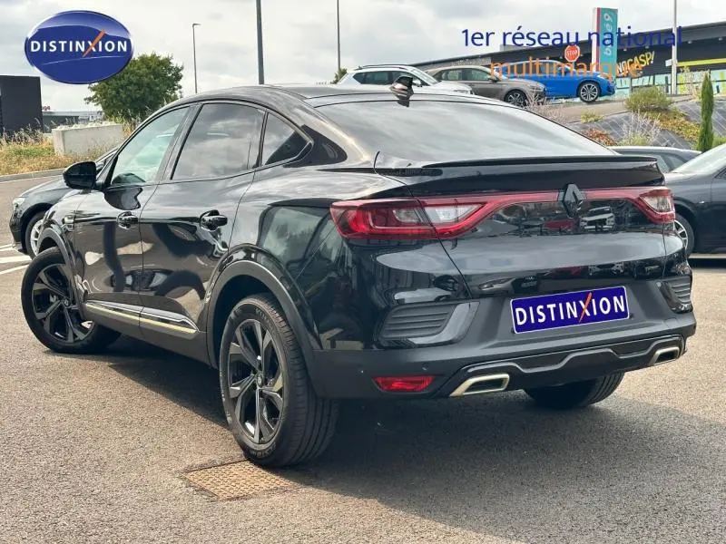 Vue 3/4 arrière droite d'une Renault Arkana noir métal 2023 avec jantes alu et double sortie d'échappement intégrée