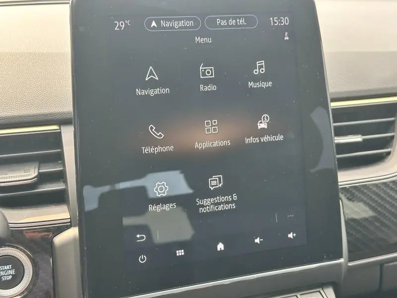 Écran tactile central du tableau de bord du Renault Arkana noir métal, affichant le menu multimédia et navigation.