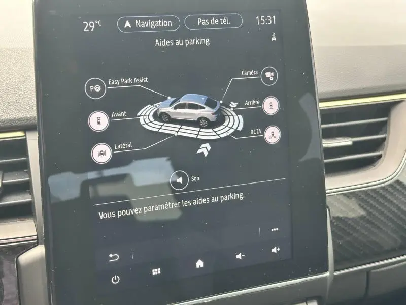 Écran tactile intérieur de la Renault Arkana noir métal affichant l'aide au parking avec vue du véhicule en 3D.