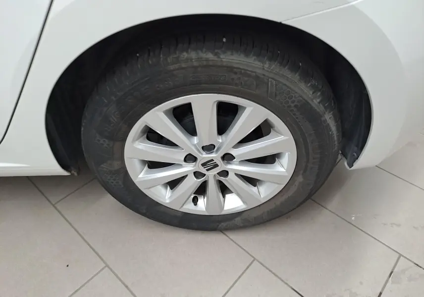 Gros plan sur la roue avant gauche blanche d'une SEAT Ibiza 2023 avec jante argentée et logo central visible.