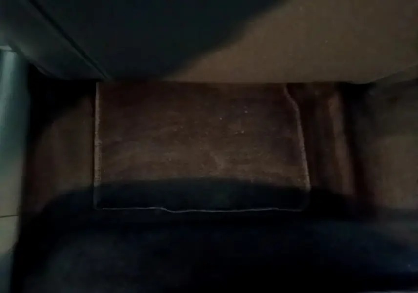 Gros plan sur le tapis de sol noir à l'arrière d'une Citroën C4 gris foncé, intérieur sombre.