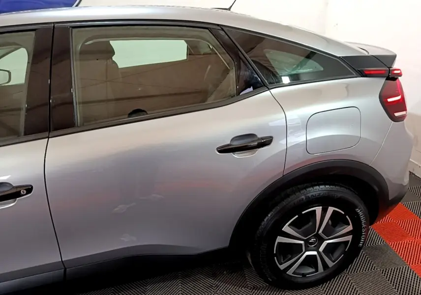 Vue côté droit arrière d'une Citroën C4 gris foncé avec jante alliage et feux arrière LED distinctifs.