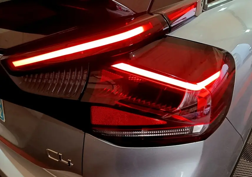 Gros plan sur le feu arrière droit allumé d'une Citroën C4 gris foncé, soulignant ses lignes LED distinctives.