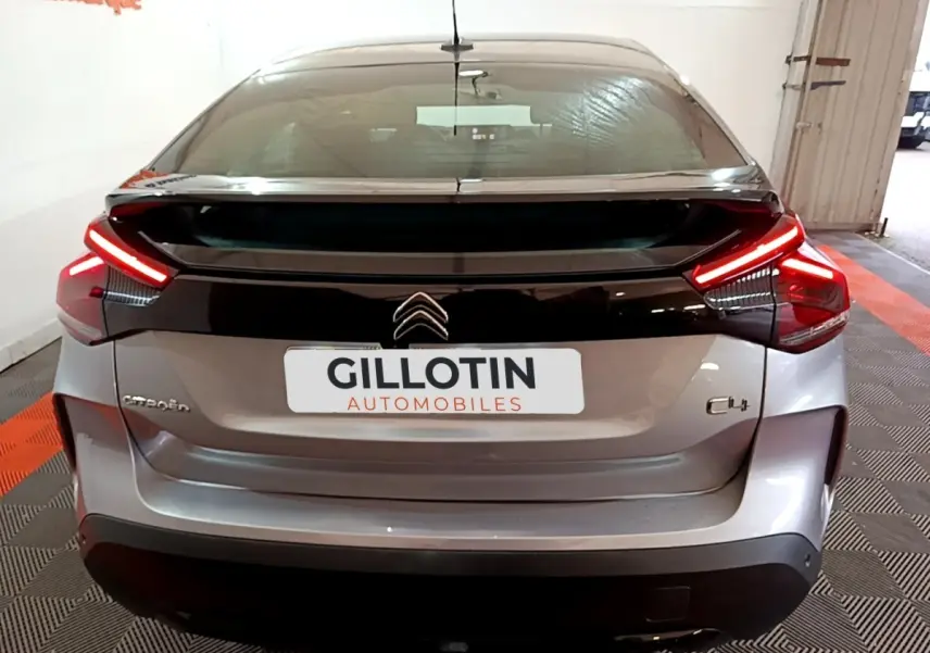 Vue arrière d'une Citroën C4 gris foncé avec feux LED en forme de boomerang et hayon noir brillant.