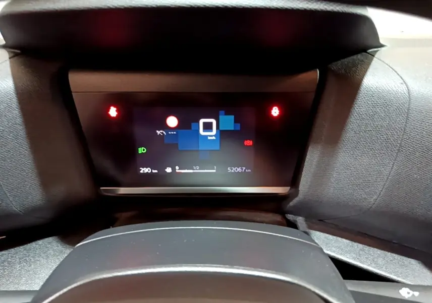 Tableau de bord numérique de Citroën C4 gris foncé, affichant 52 067 km et indicateurs lumineux rouges.