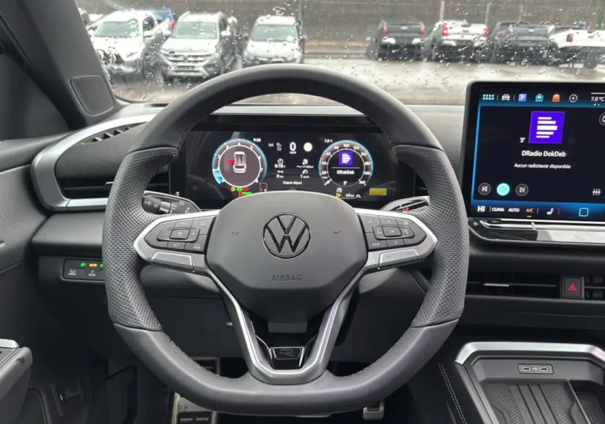 Vue centrée sur le volant cuir multifonctions du Volkswagen T-Roc 2026 avec tableau de bord digital et écran tactile.