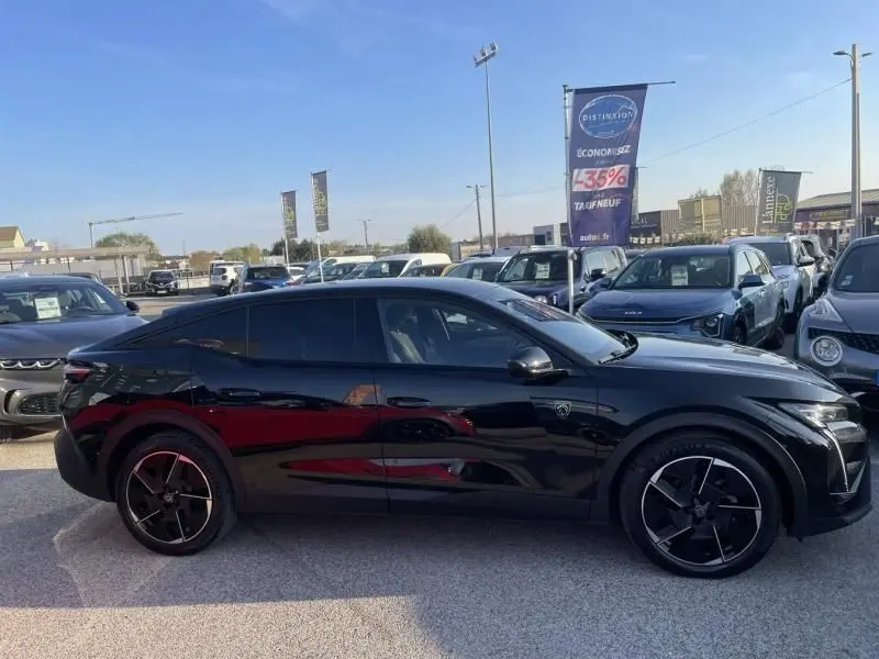 Peugeot 408 Hybrid 136 cv GT noir métal vue de profil côté gauche sur un parking en extérieur.