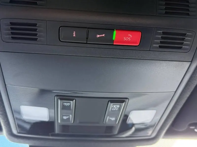 Vue en gros plan du panneau de commandes au plafond intérieur du SEAT Arona 2025, avec bouton SOS rouge et éclairage intégré.