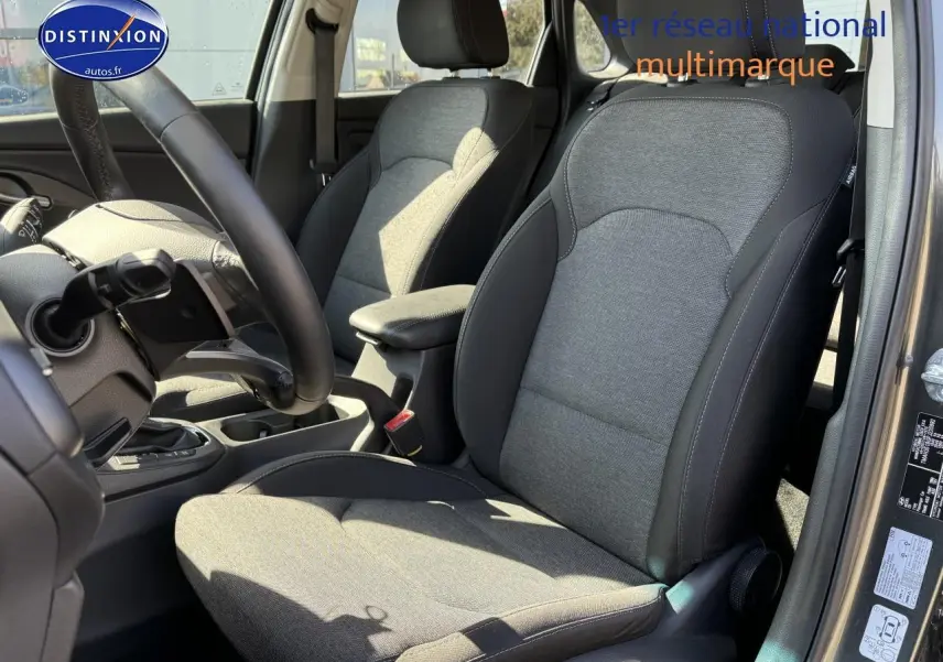 Intérieur avant droit de la Hyundai i30 2024 gris anthracite, sièges tissu avec volant cuir multifonction visible.