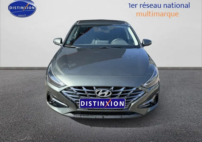 Vue frontale d'une Hyundai i30 gris anthracite 2024 avec calandre chromée et phares LED fins.