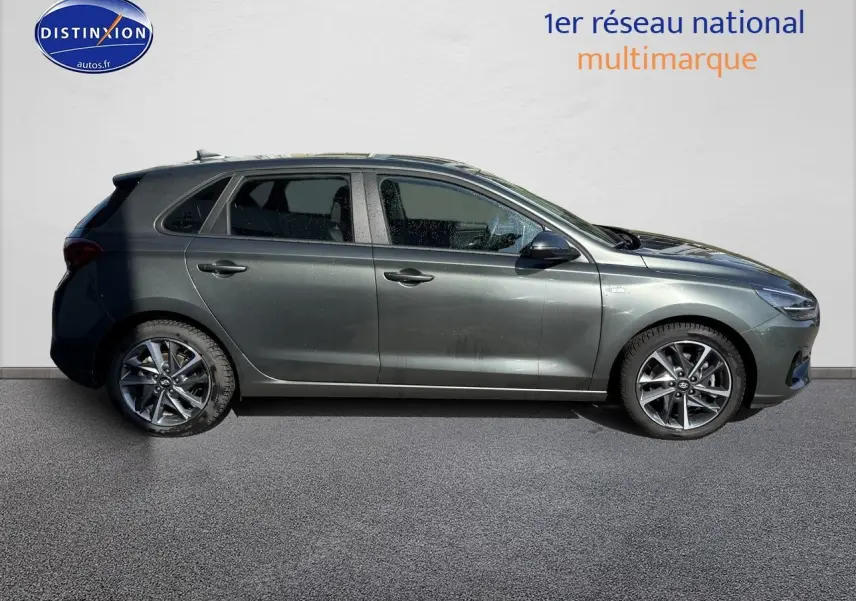 Profil côté gauche d'une Hyundai i30 gris anthracite 2024 avec jantes alliage et vitres teintées.