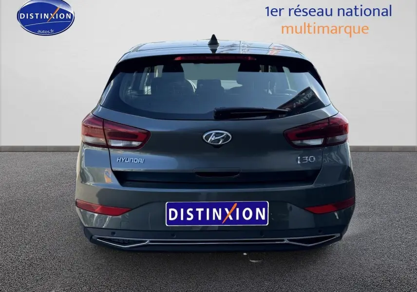 Vue arrière d'une Hyundai i30 gris anthracite 2024 avec feux LED et logo distinctif sur fond neutre.