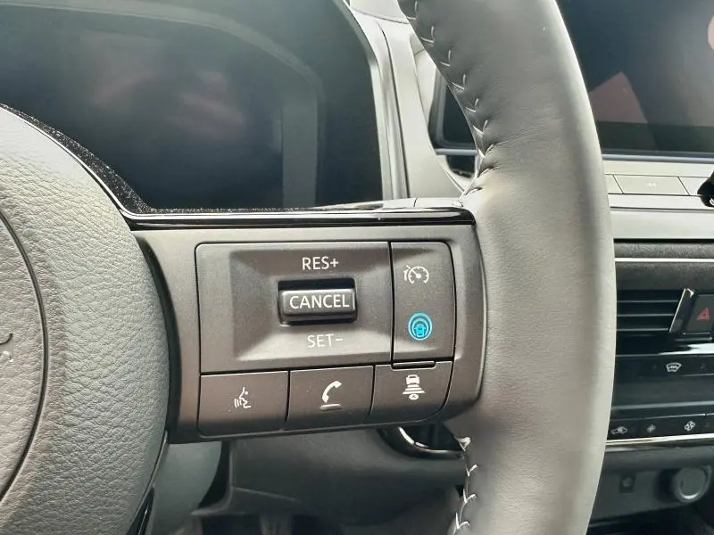 Gros plan sur les commandes au volant cuir noir du Nissan Qashqai e-POWER 190ch N-Design 2025, affichant le régulateur de vitesse.