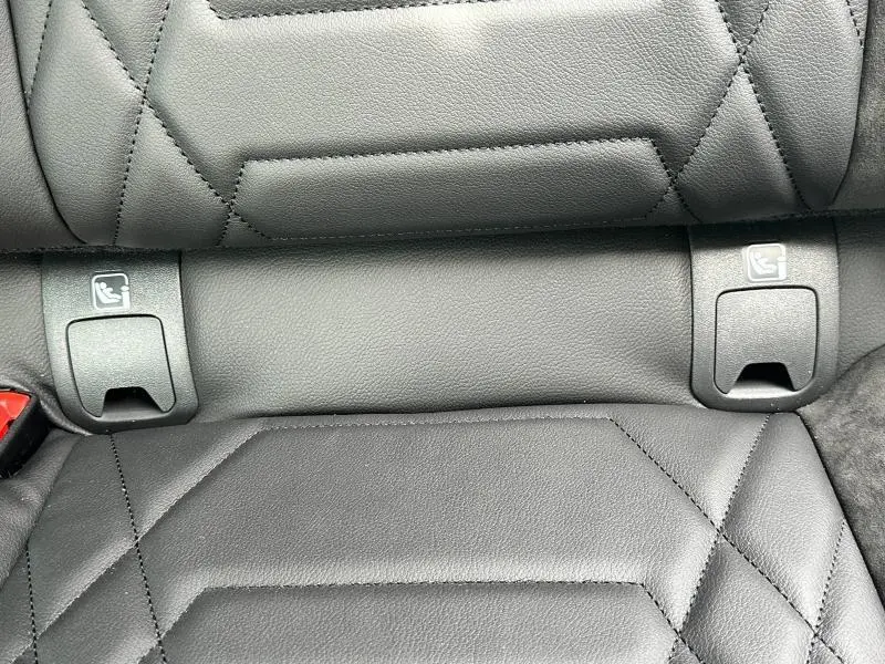 Gros plan sur la sellerie noire en cuir du siège arrière du Nissan Qashqai e-POWER 190ch N-Design 2025, avec fixations ISOFIX visibles.