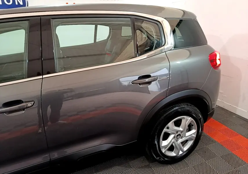 Vue côté droit arrière d'un Citroën C5 Aircross gris foncé avec jante alliage 17 pouces et vitres surteintées.