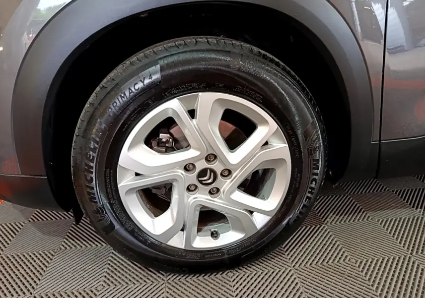 Gros plan sur la roue arrière droite d’un Citroën C5 Aircross gris foncé avec passage de roue noir mat.