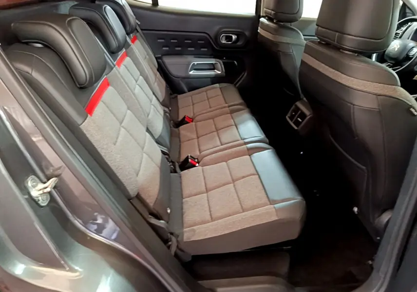 Vue intérieure côté gauche montrant la banquette arrière en tissu gris et cuir noir du Citroën C5 Aircross gris foncé.
