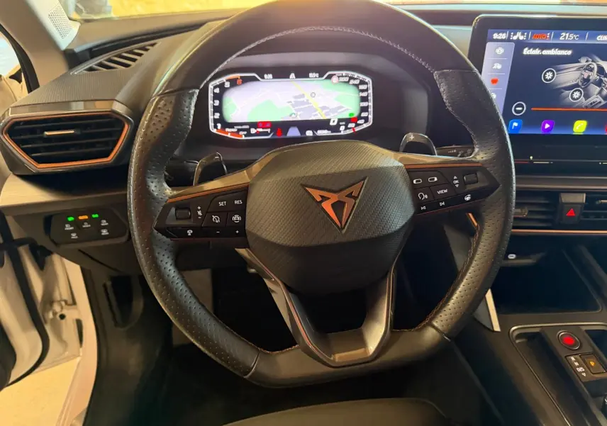 Vue arrière ouverte du coffre d'une CUPRA Leon ST blanche 2024, avec feux arrière allumés en intérieur.