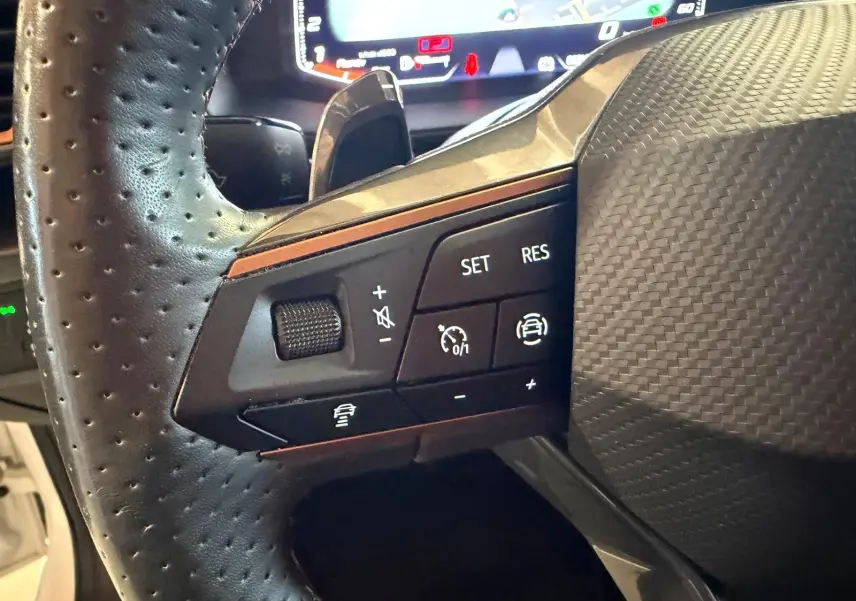 Vue arrière ouverte sur le coffre spacieux d'une CUPRA LEON ST blanche 2024, avec cache-bagages et sièges noirs visibles.