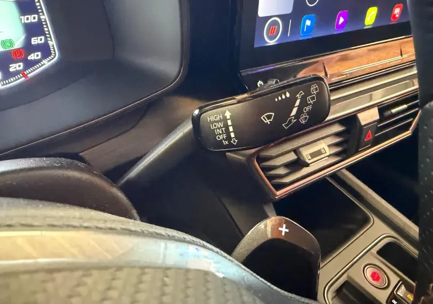 Détail de la poignée intérieure côté gauche d’une CUPRA LEON ST blanche, avec surpiqûres et bouton de lève-vitre.
