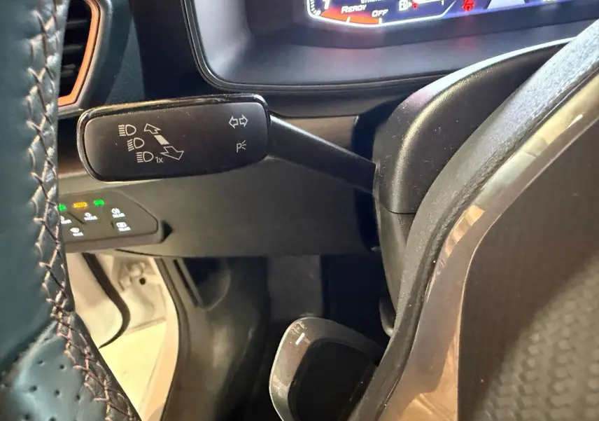 Vue intérieure de la porte avant gauche blanche d'une CUPRA LEON ST 2024 avec garniture noire et surpiqûres contrastées.