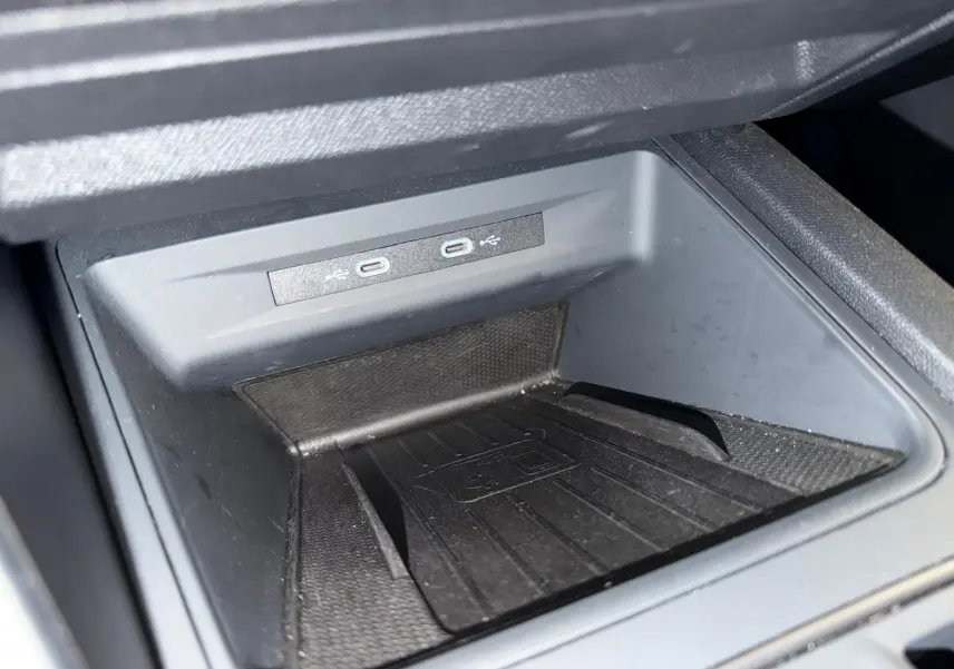 Vue intérieure côté conducteur de la CUPRA LEON ST 2024, sièges noirs avec surpiqûres blanches et console centrale moderne.