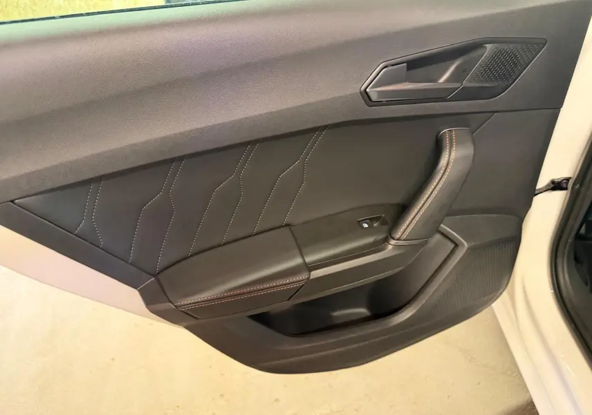 Gros plan sur la manette de clignotants à gauche du volant dans l’habitacle noir du CUPRA LEON ST 2024.