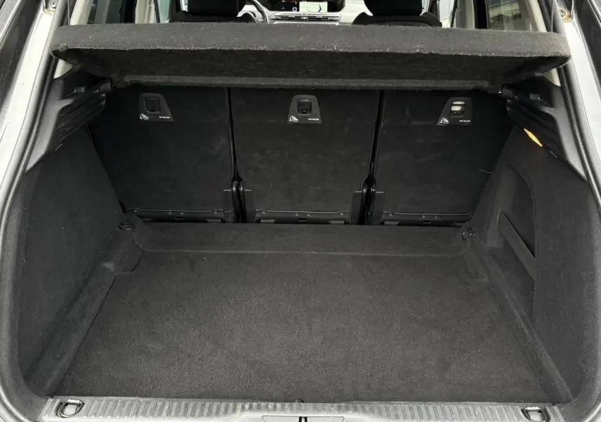 Coffre ouvert d'une Citroën C4 Spacetourer gris foncé, vue arrière montrant l'espace de chargement et la tablette de séparation.