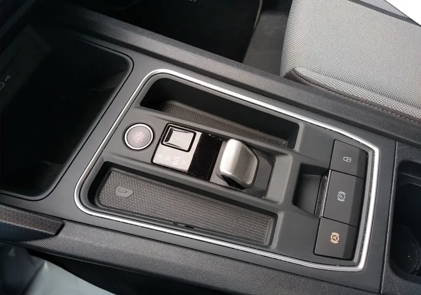 Gros plan sur la console centrale grise du SEAT LEON ST 2022, mettant en valeur la commande de boîte auto DSG et les boutons de contrôle.