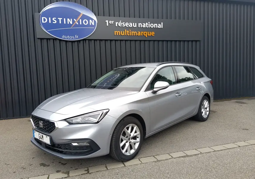 SEAT LEON ST gris vue 3/4 avant droit, garée devant un mur noir avec enseigne Distinxion.