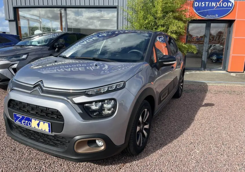 Citroën C3 gris vue 3/4 avant droit, avec projecteurs LED et protections latérales noires.