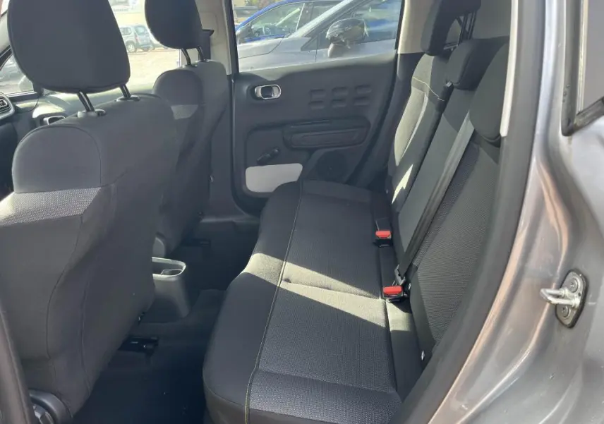 Intérieur arrière de la Citroën C3 gris, vue côté droit montrant les sièges arrière en tissu noir et la portière ouverte.